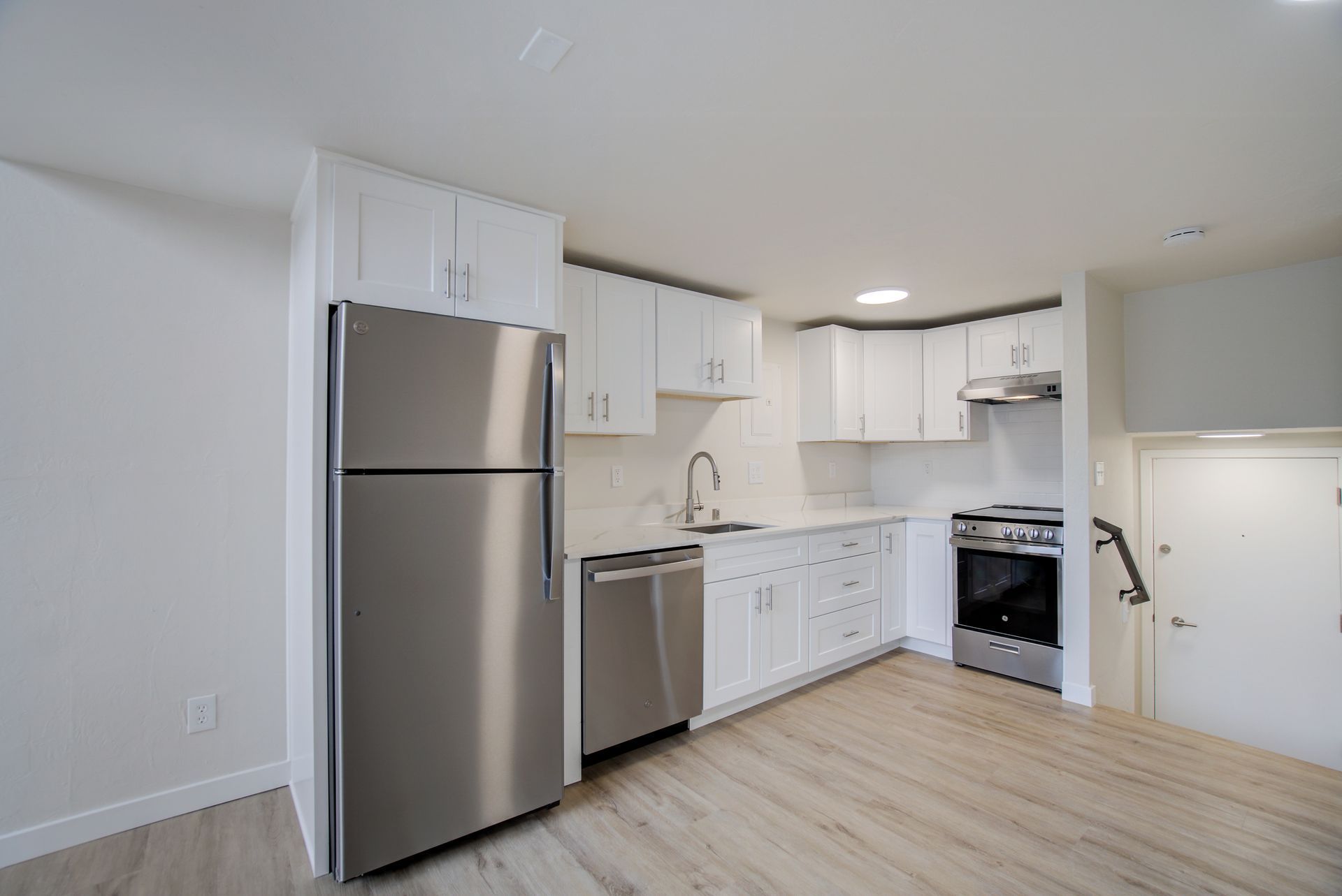 A kitchen with stainless steel appliances and white cabinets