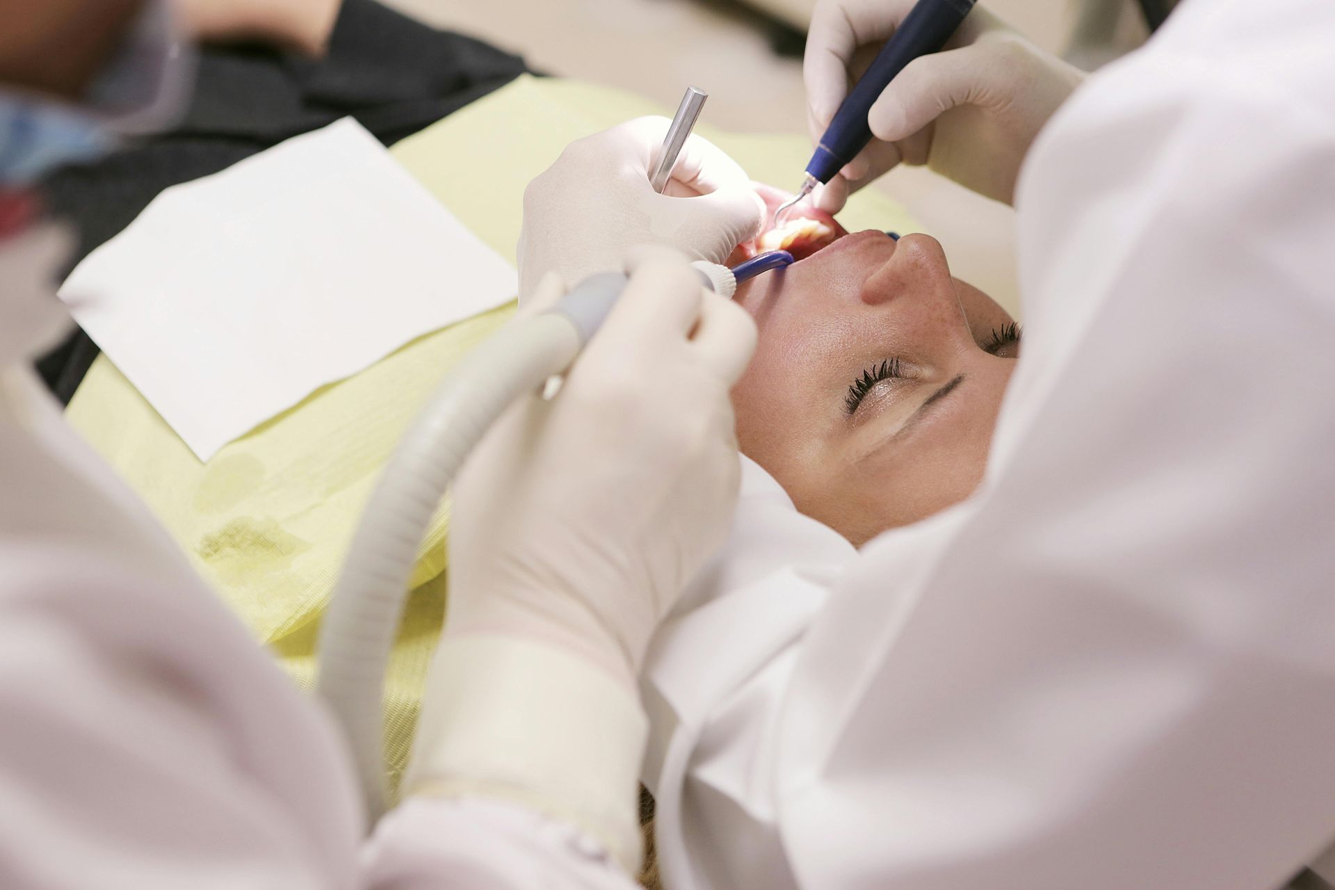 Dentist treating a patient’s mouth with bright dental tools