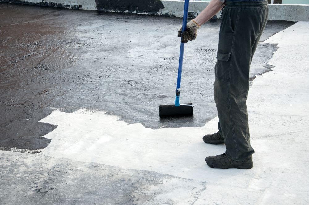 Worker Painting The Roller Brush, For Waterproofing — Bananacoast Waterproofing in Yamba, NSW