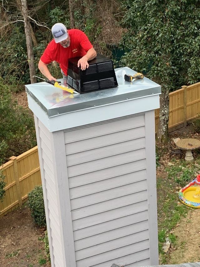 Worker in red shirt repairing a rooftop vent on a white shed