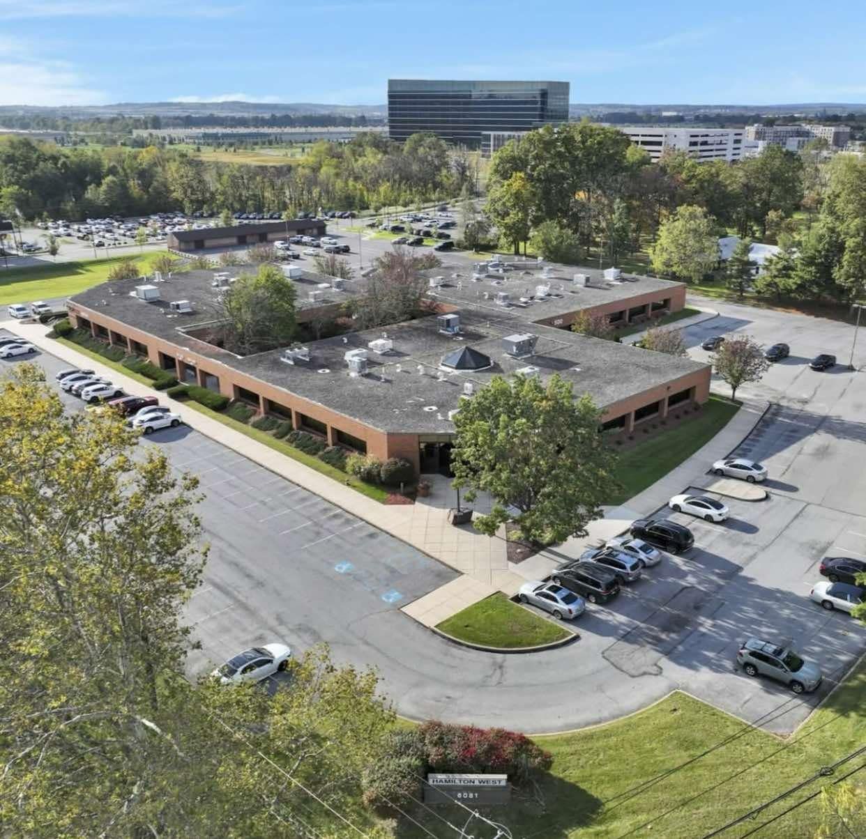 An aerial view of a large building with a lot of cars parked in front of it.