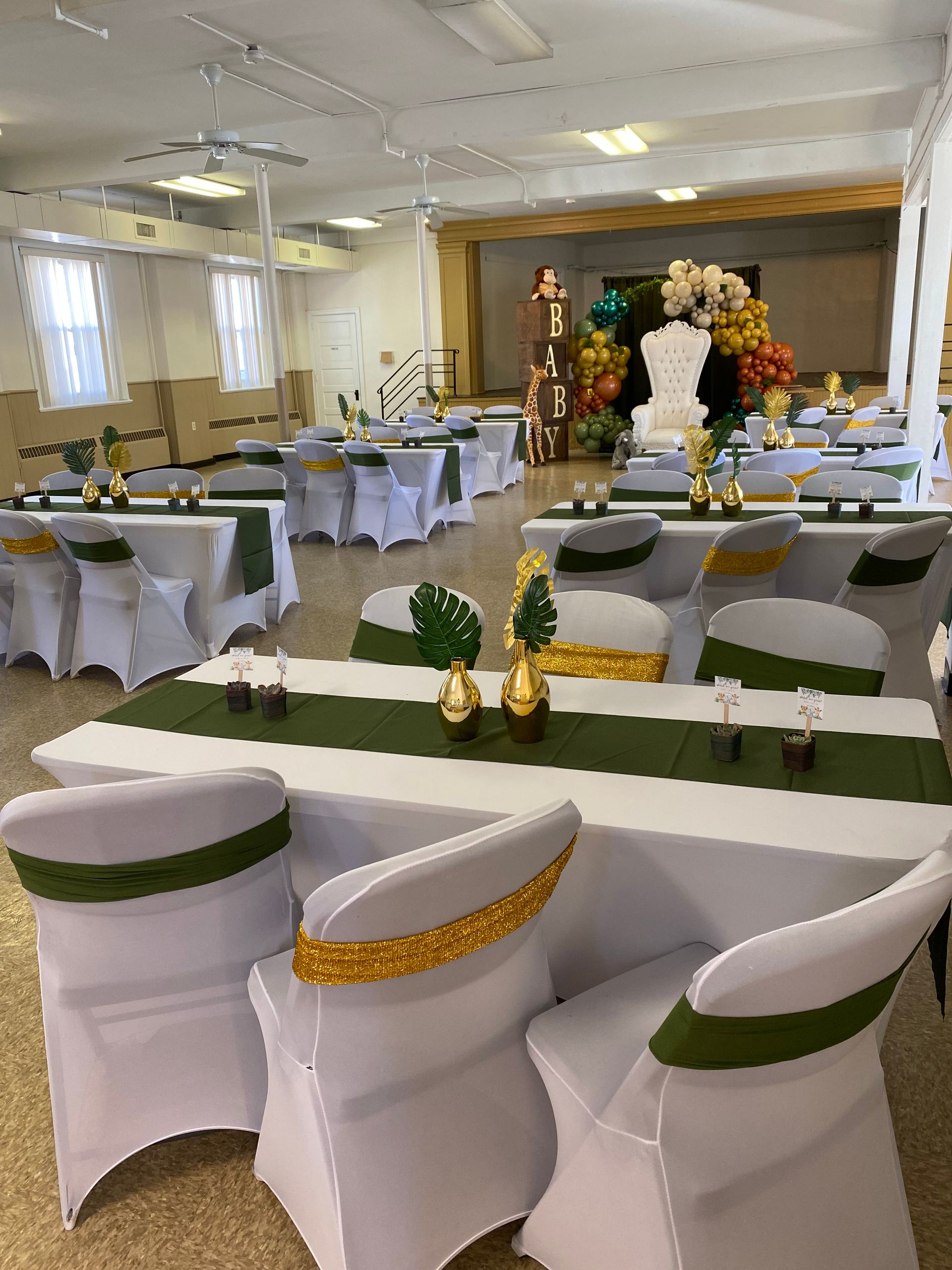 A large room with tables and chairs set up for a party.