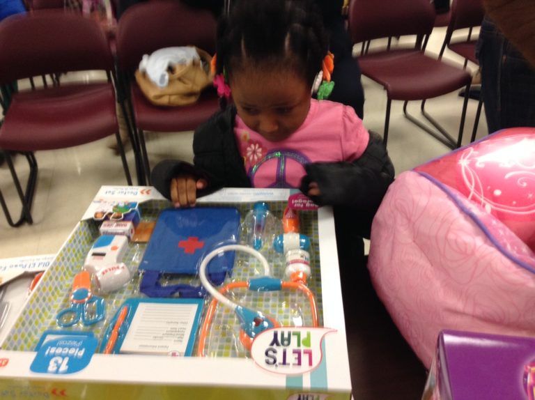 Little Girl Looking at Her New Toy