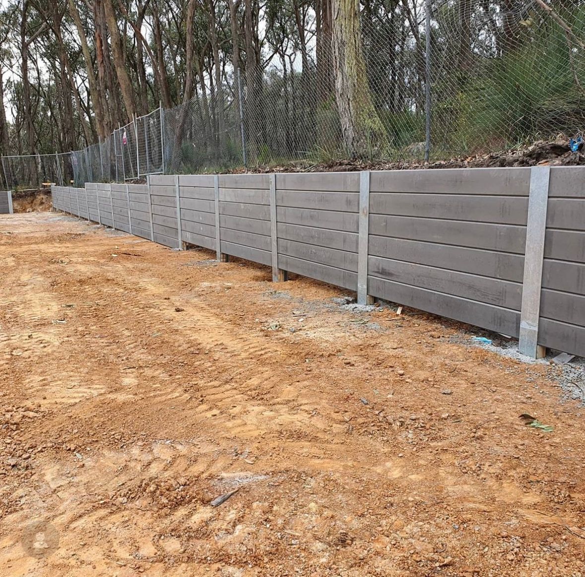 A stone wall with a metal fence surrounding it.