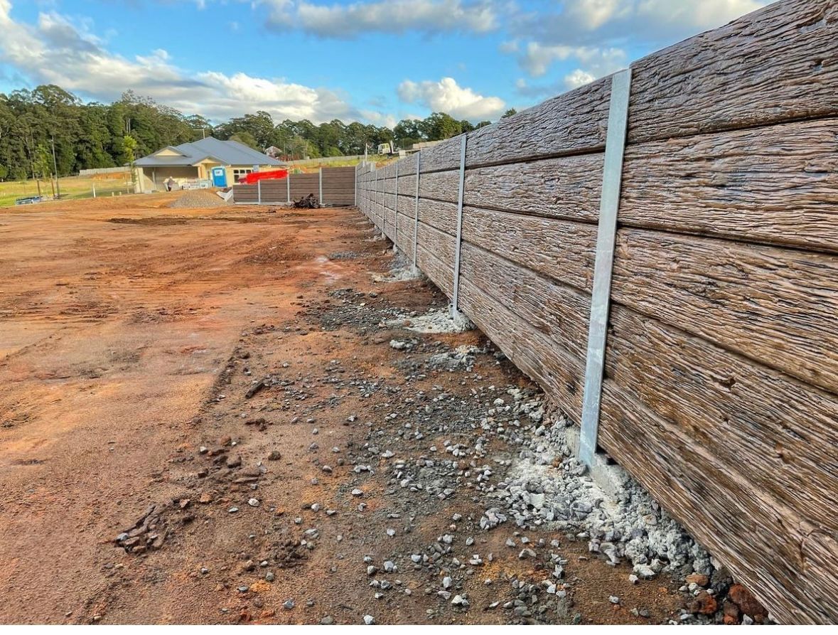 A fence is being built in the middle of a dirt field.
