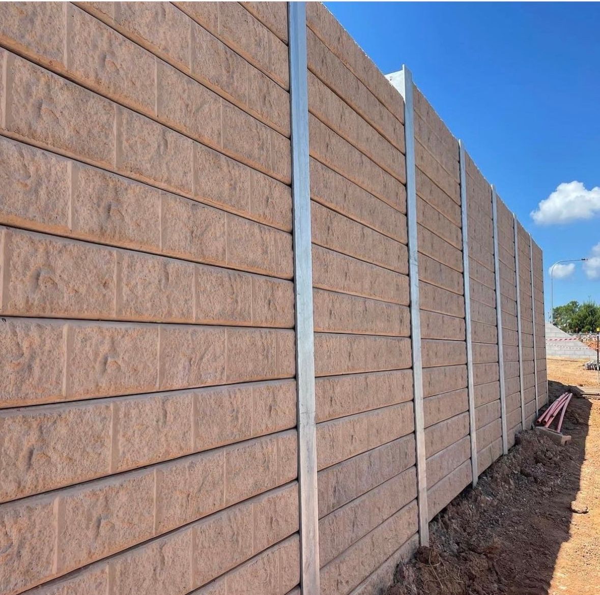 A brick wall with a blue sky in the background.