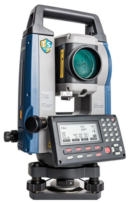 Digital surveying total station with lens, keypad, and display on a tripod mount