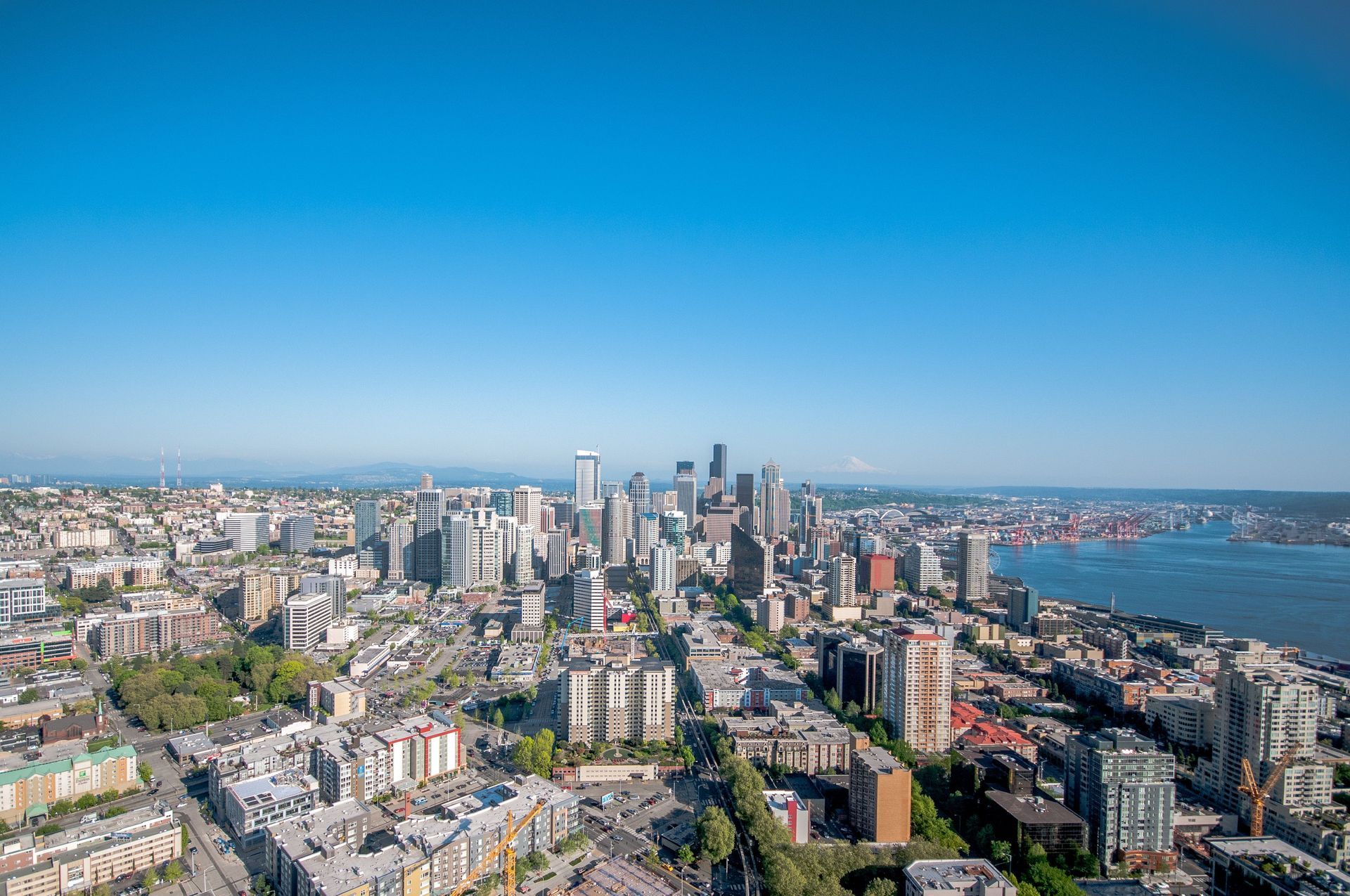 Aerial view of the Seattle skyline with high-rises, dense buildings, and blue sea under a clear sky