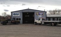 A small auto repair shop with two trucks parked outside. | Mohr's Automotive