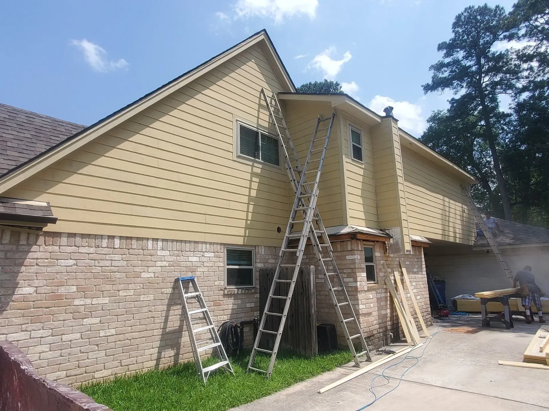 House exterior with ladders and scaffolding during siding repair