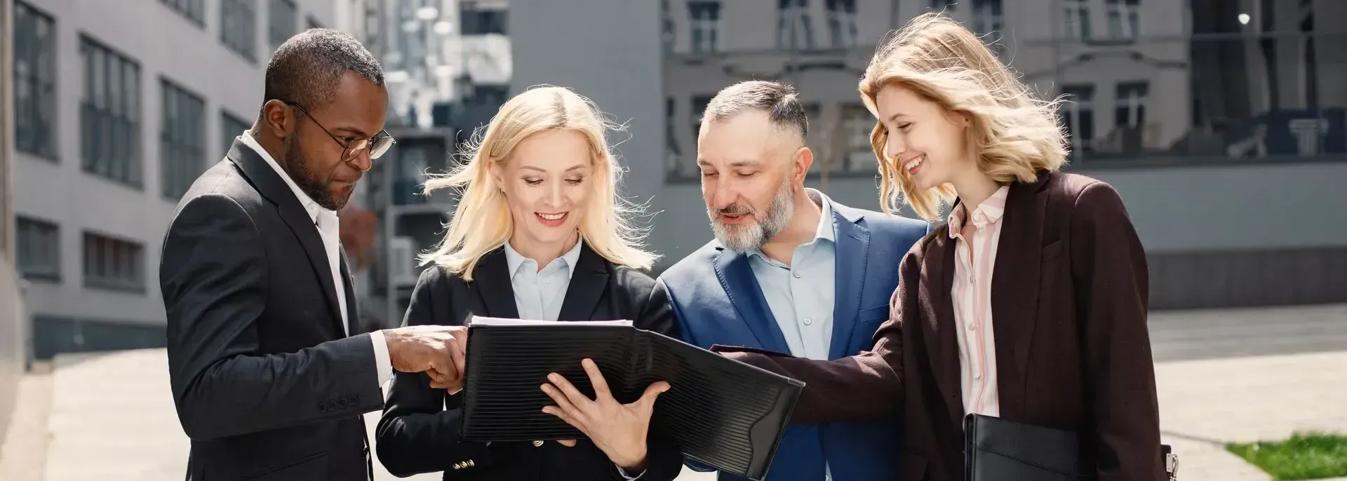 A group of business people are looking at a tablet computer.