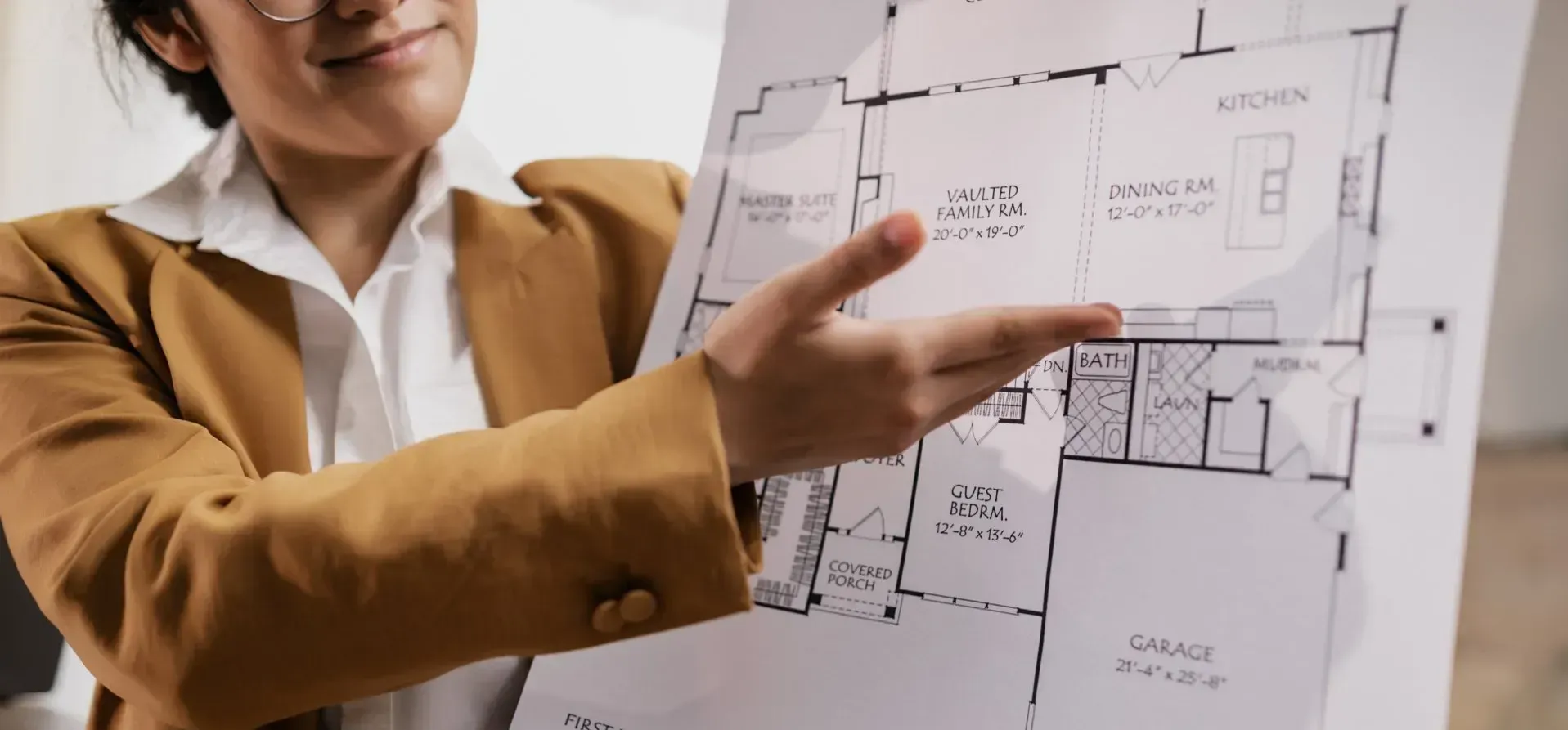 A woman is pointing at a floor plan of a house.