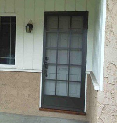 Front porch with a black screen door, white siding, tan stucco, and a wall lantern.