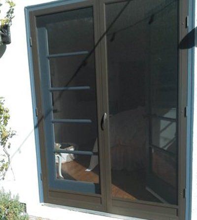 Open sliding glass door with dark screen and a chair visible inside the entryway