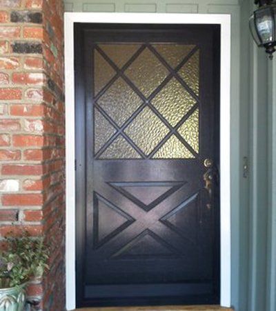 Dark front door with diamond-pattern glass panels set in a brick exterior doorway