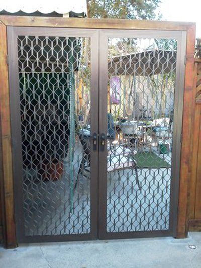 Brown metal gate with wire mesh panels, viewed from the front