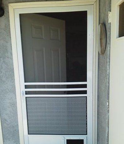 White screen door with a mesh lower panel and open glass upper panel on a porch