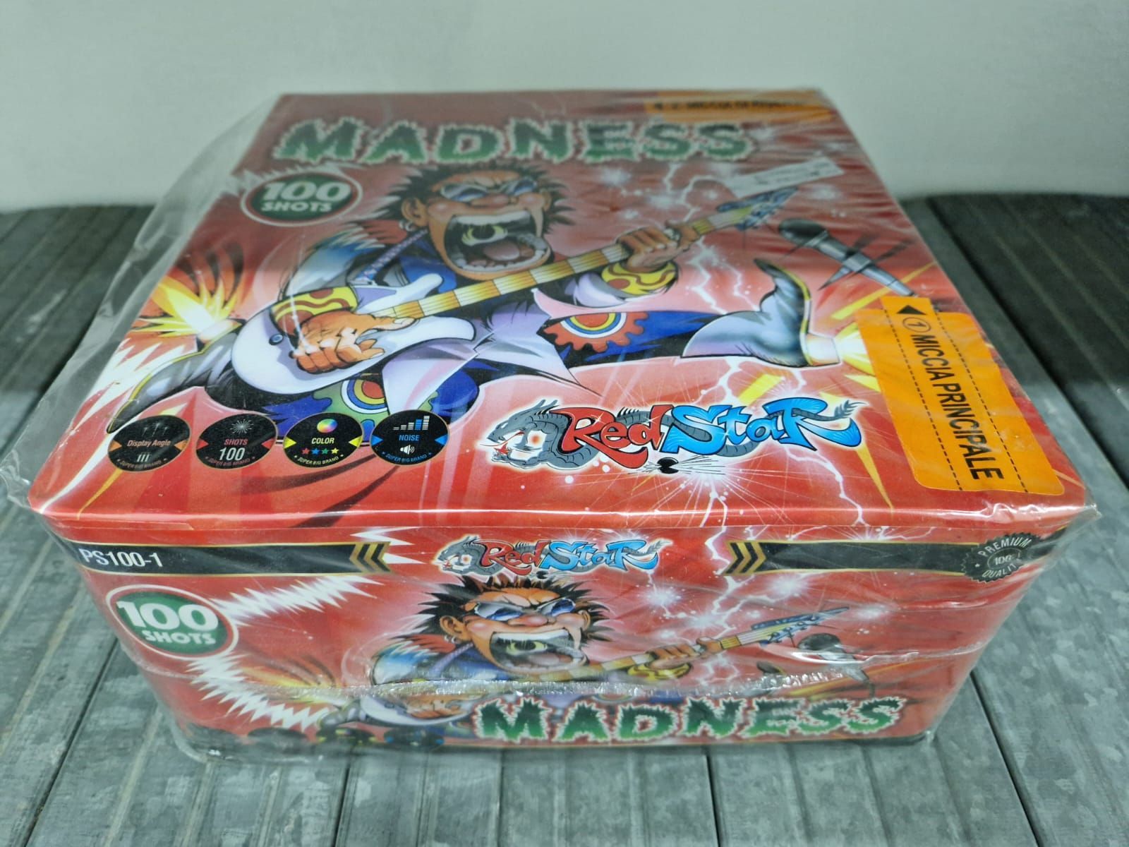 Scatola rossa per figurine collezionabili MADNESS con illustrazioni a fumetti colorate e loghi circolari sul coperchio.