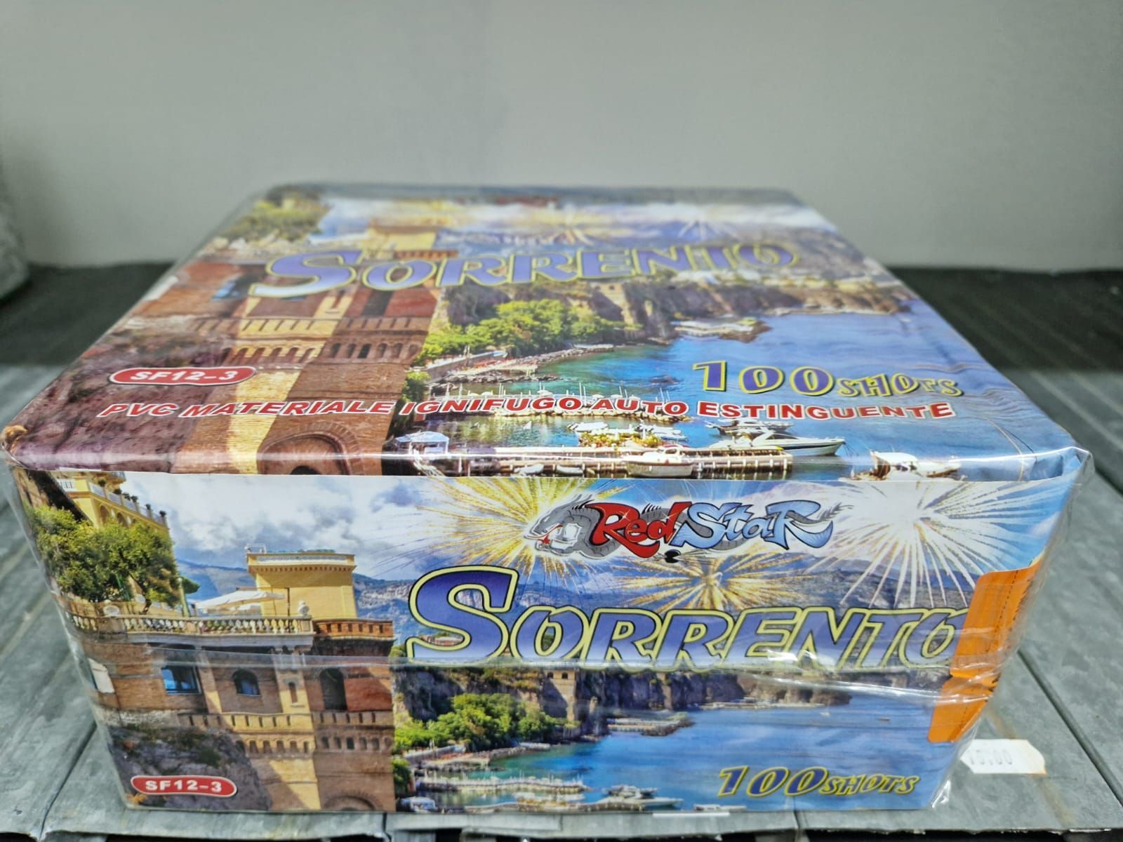 Scatola puzzle blu a tema Sorrento con illustrazione di un paesaggio urbano costiero su sfondo grigio.