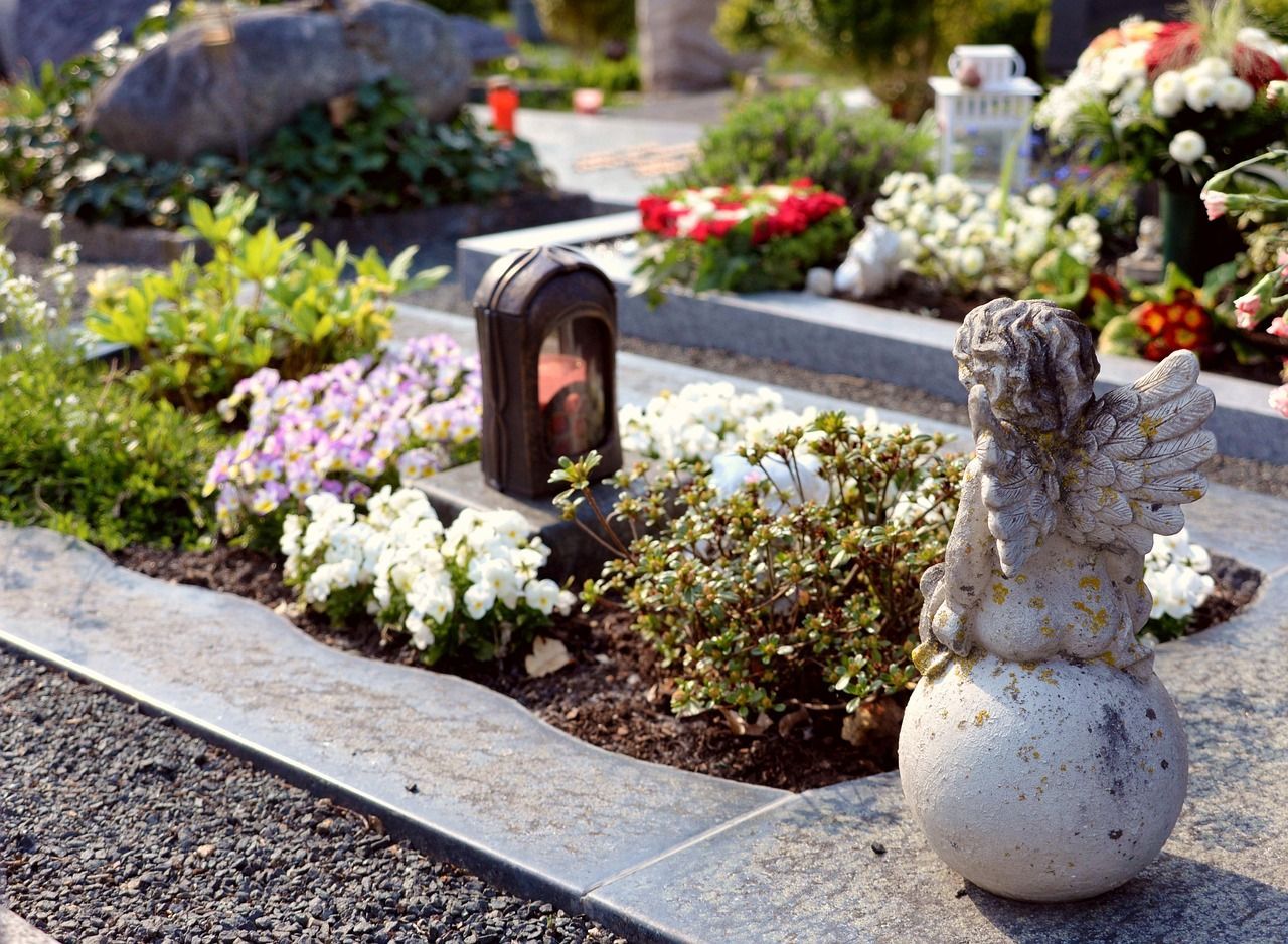 Angel statue beside a tomb symbolizing care and remembrance at a gravesite