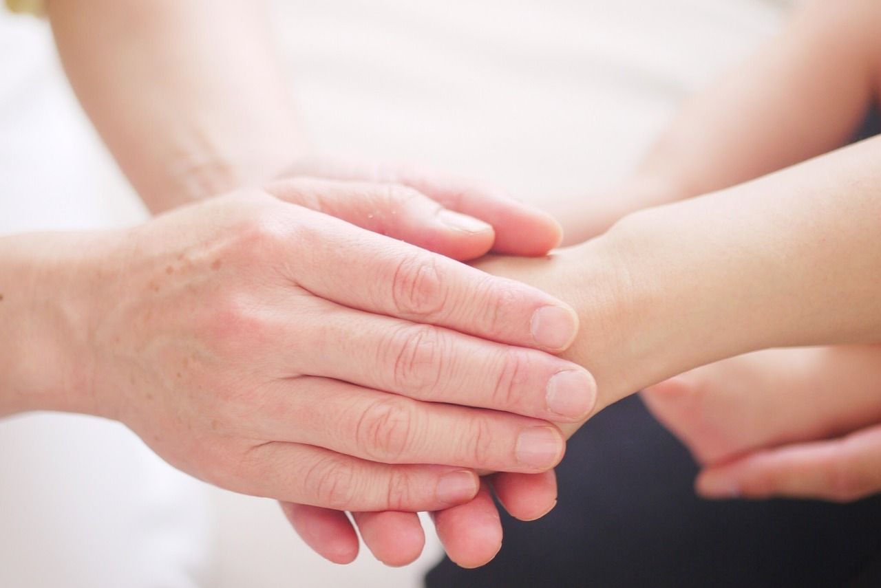 Hands of a parent and child gently holding each other, symbolizing love, comfort, and support provid