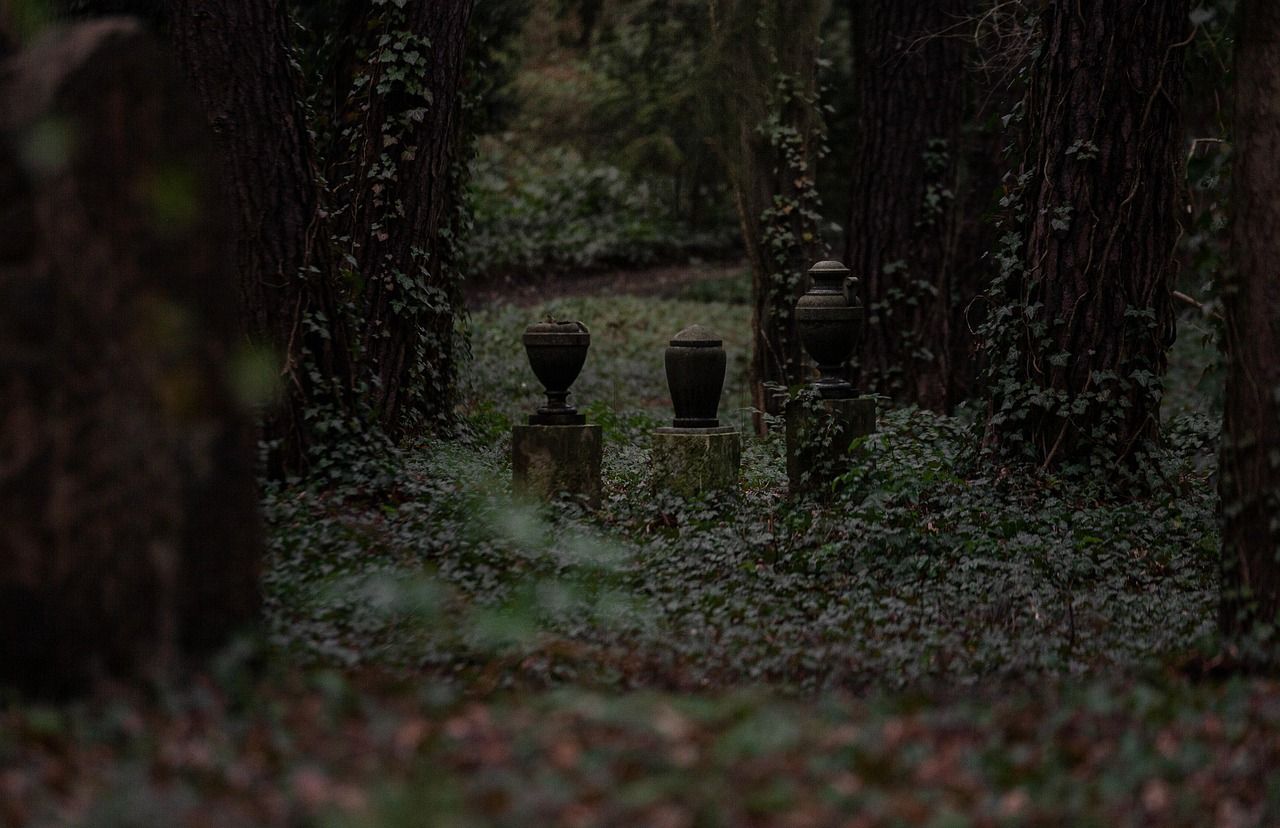 Decorative urn sculpture in a green graveyard serving as a memorial vase