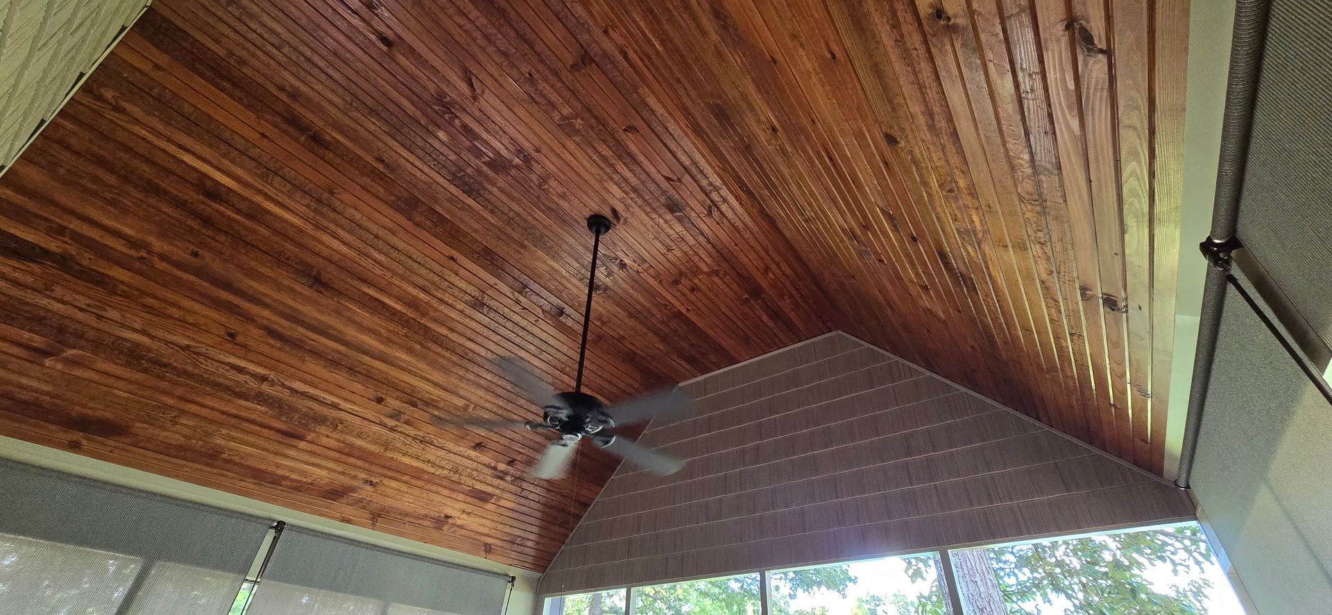 Wooden ceiling with a ceiling fan.