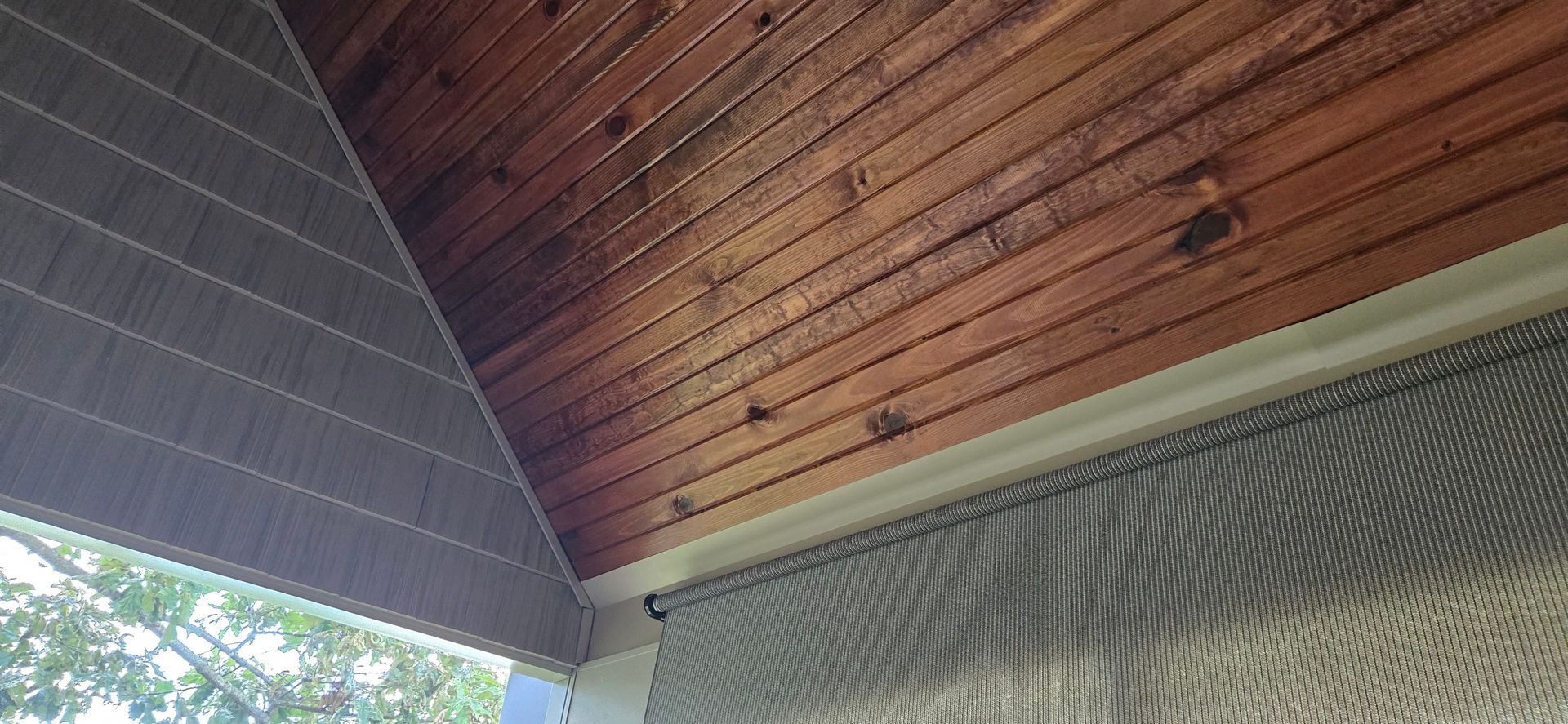 Wood ceiling with horizontal planks, gray panels, and screen.