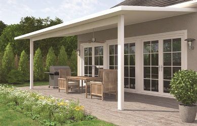 There is a patio with a table and chairs under a canopy