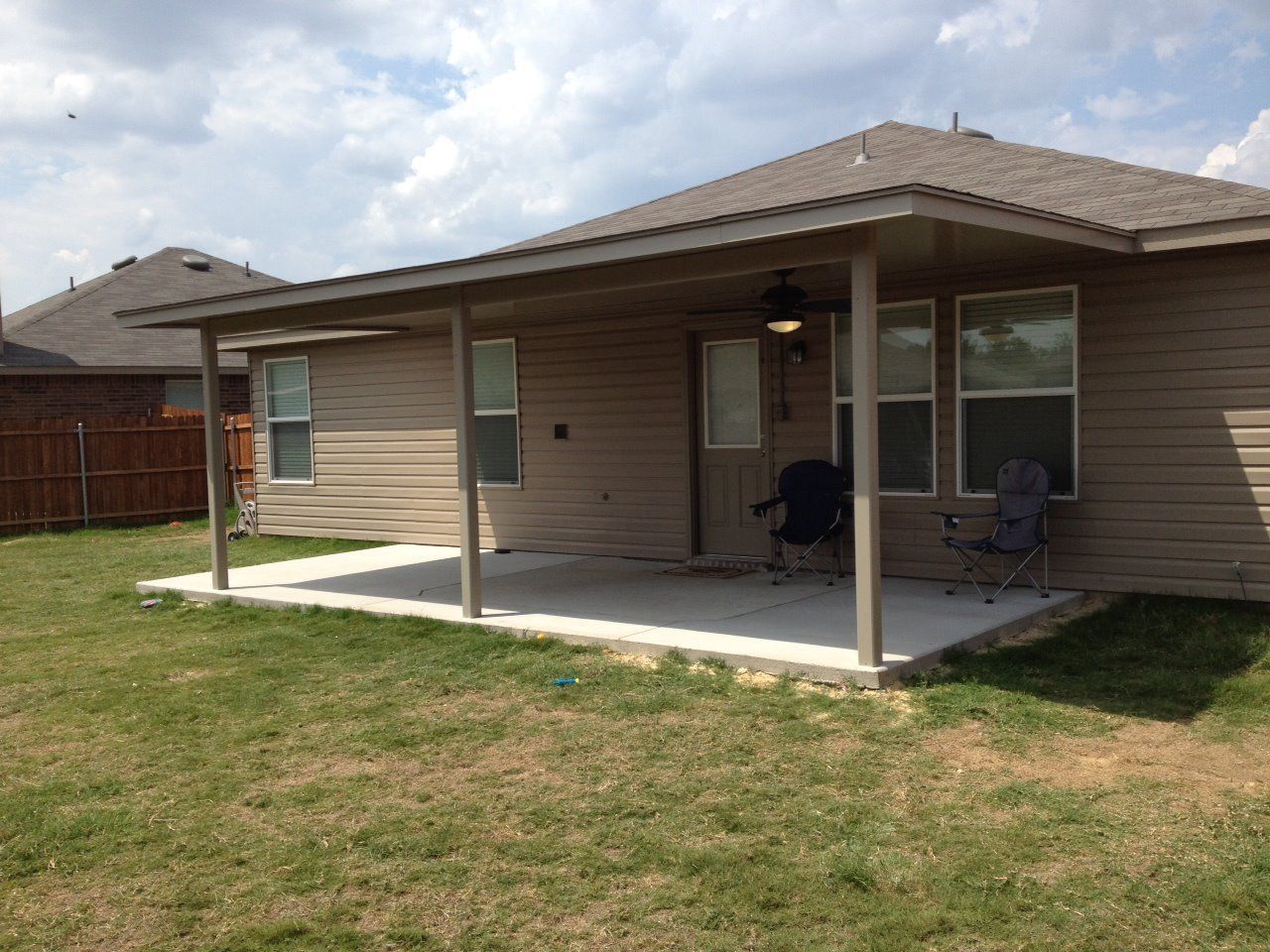 A house with a covered porch and chairs in front of it