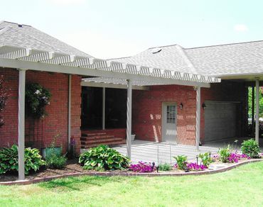 A brick house with a pergola over the front porch