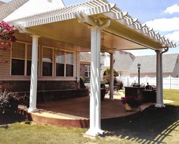 A house with a covered patio and a white fence