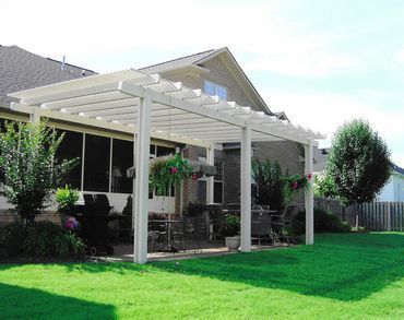 There is a pergola in the backyard of a house