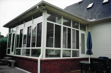 A screened in porch on the side of a house
