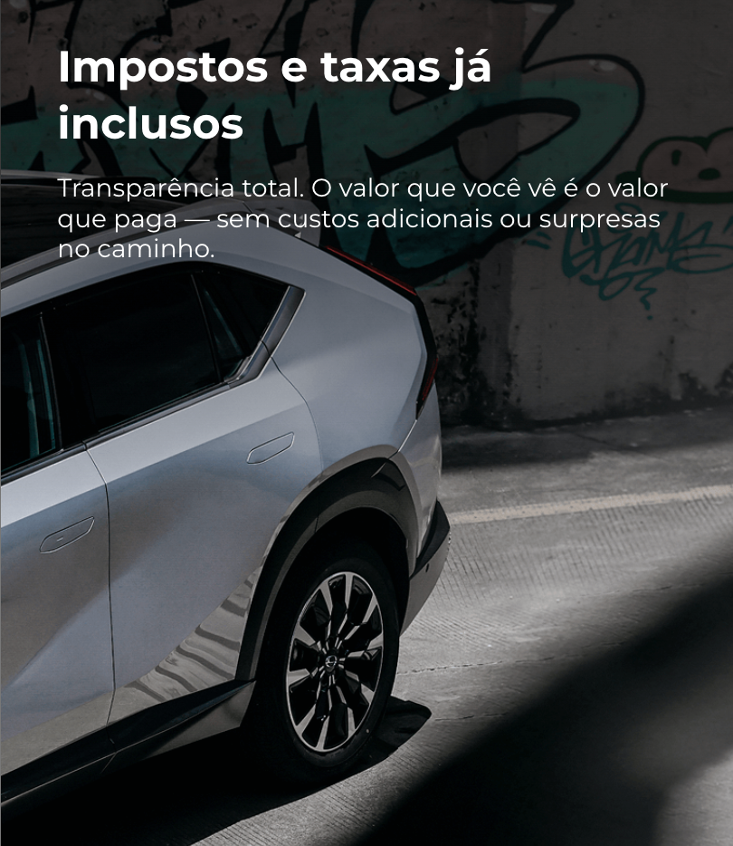 Carro cinza em estacionamento com texto: “Impostos e taxas já inclusos”