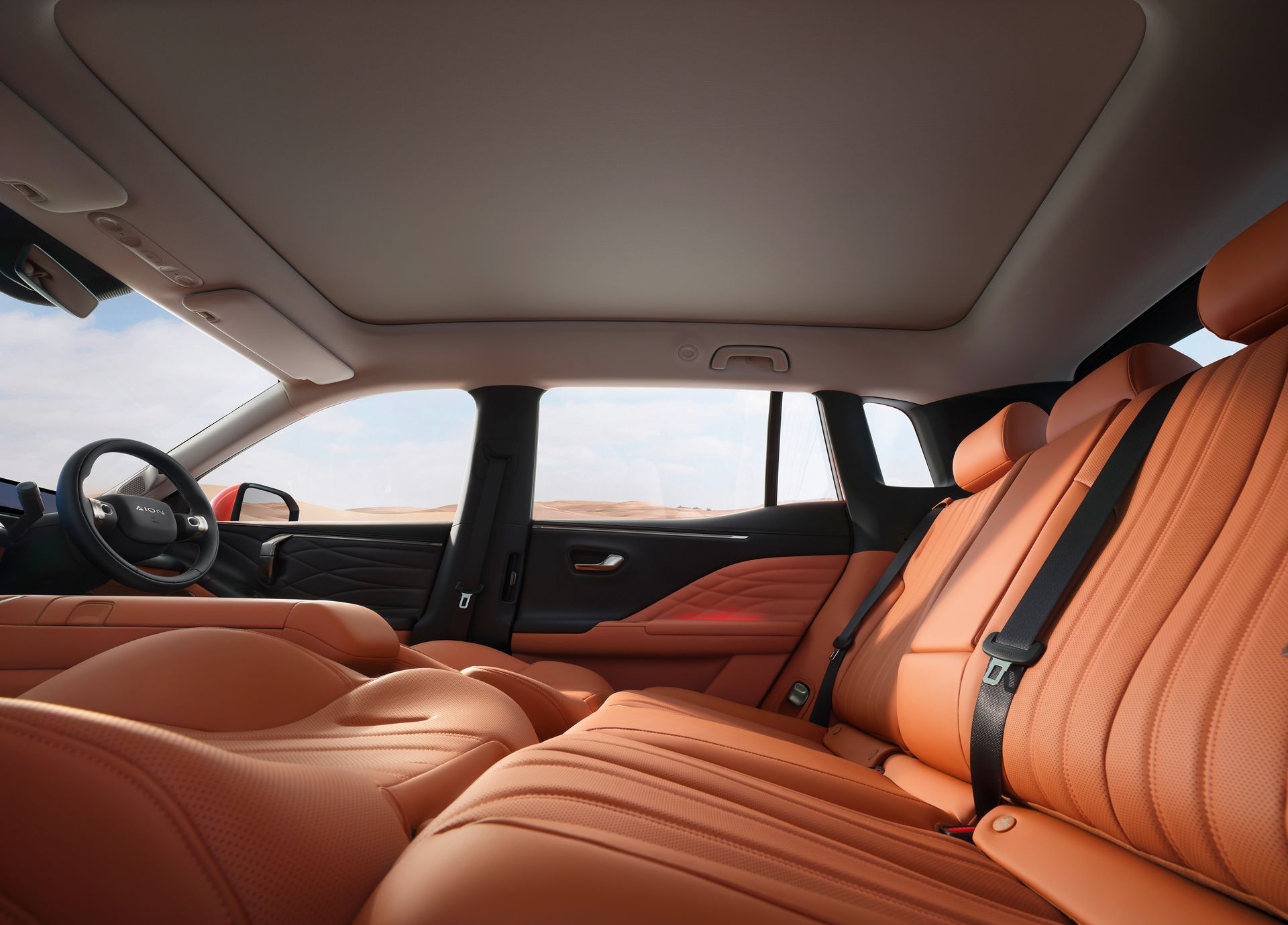 Interior de carro de luxo com bancos de couro bege e teto panorâmico, visto do banco traseiro.
