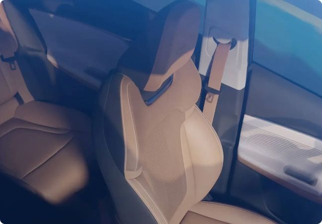 Interior do carro com bancos dianteiros bege e vidros azulados, visto do banco traseiro.
