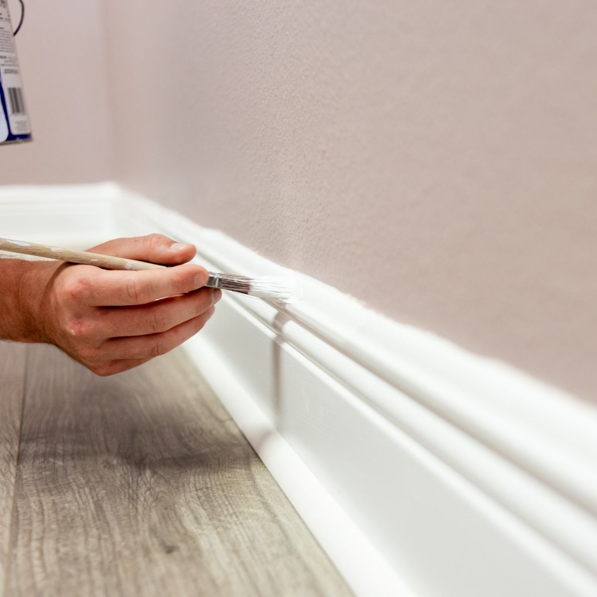 A person is painting a wall with a brush