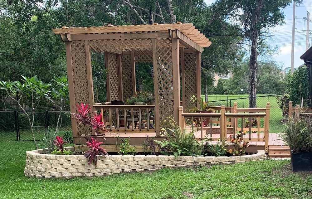 A wooden gazebo is sitting on top of a lush green lawn.