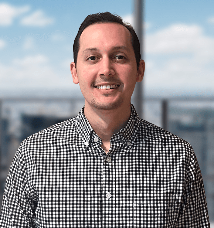 A man in a plaid shirt is smiling for the camera.