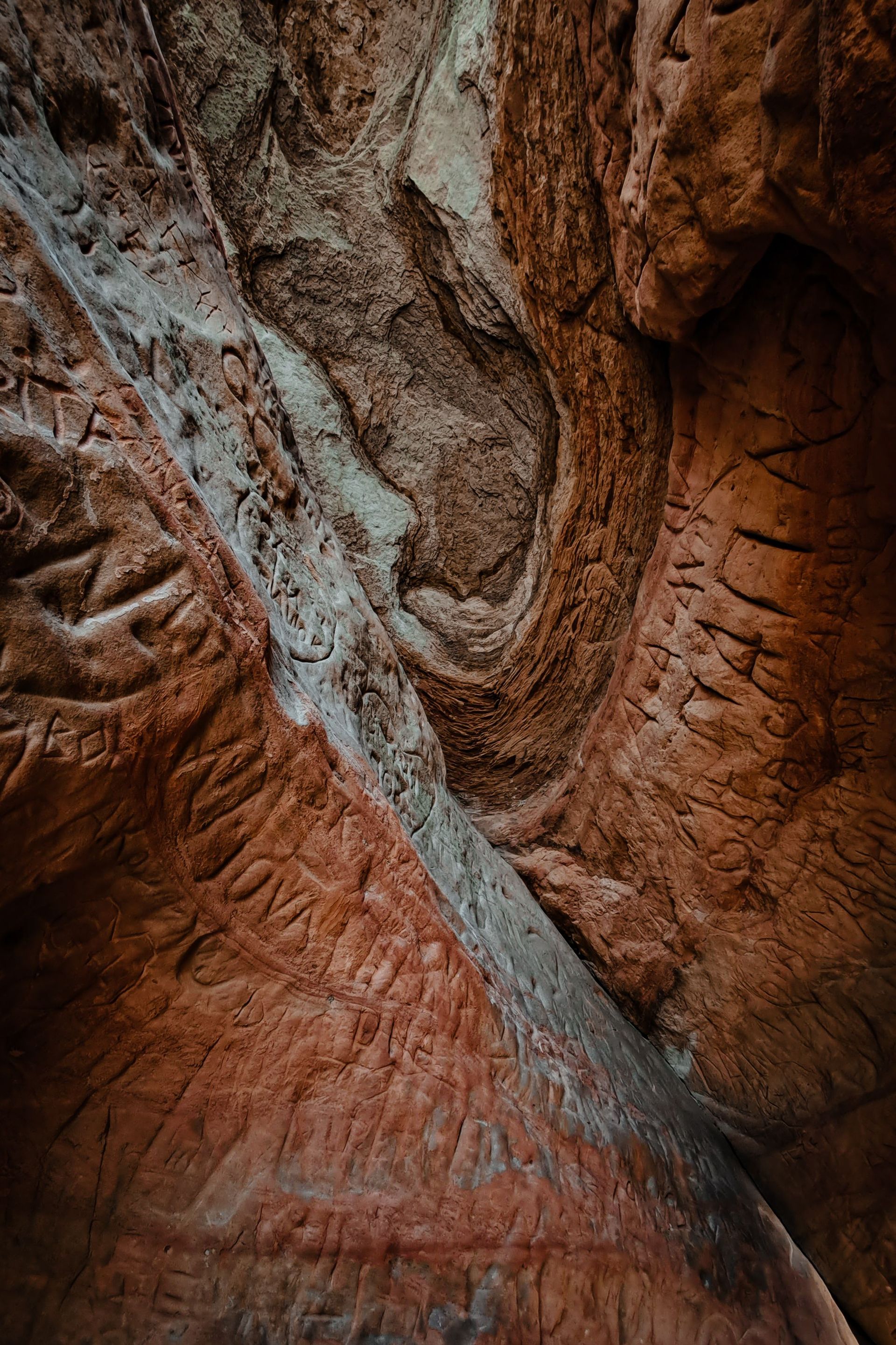 Close-up of red sandstone canyon walls with a gray rock seam running diagonally