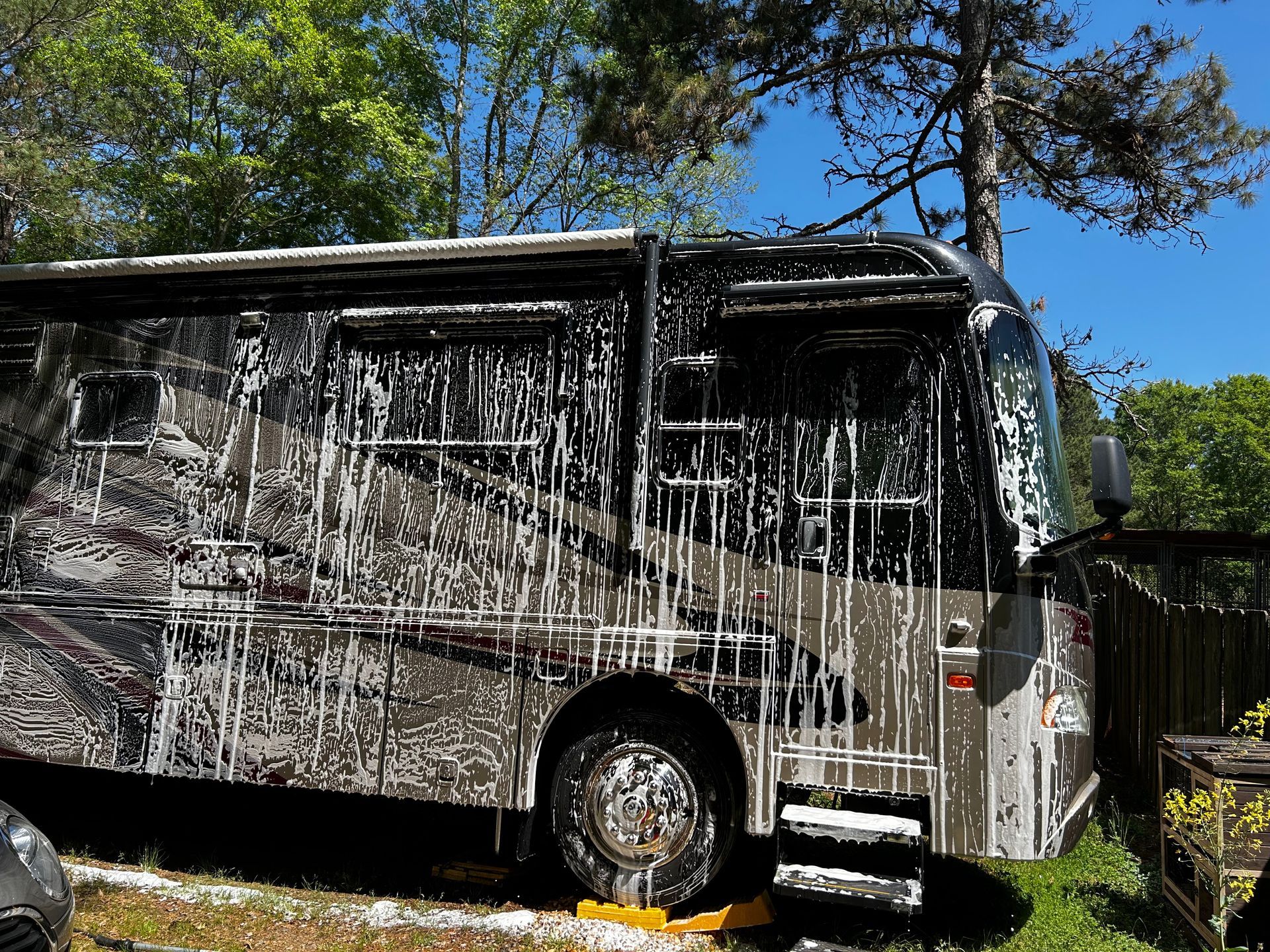 A rv is covered in foam and is being washed.