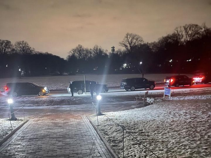 A white truck is parked in a parking lot next to a building.