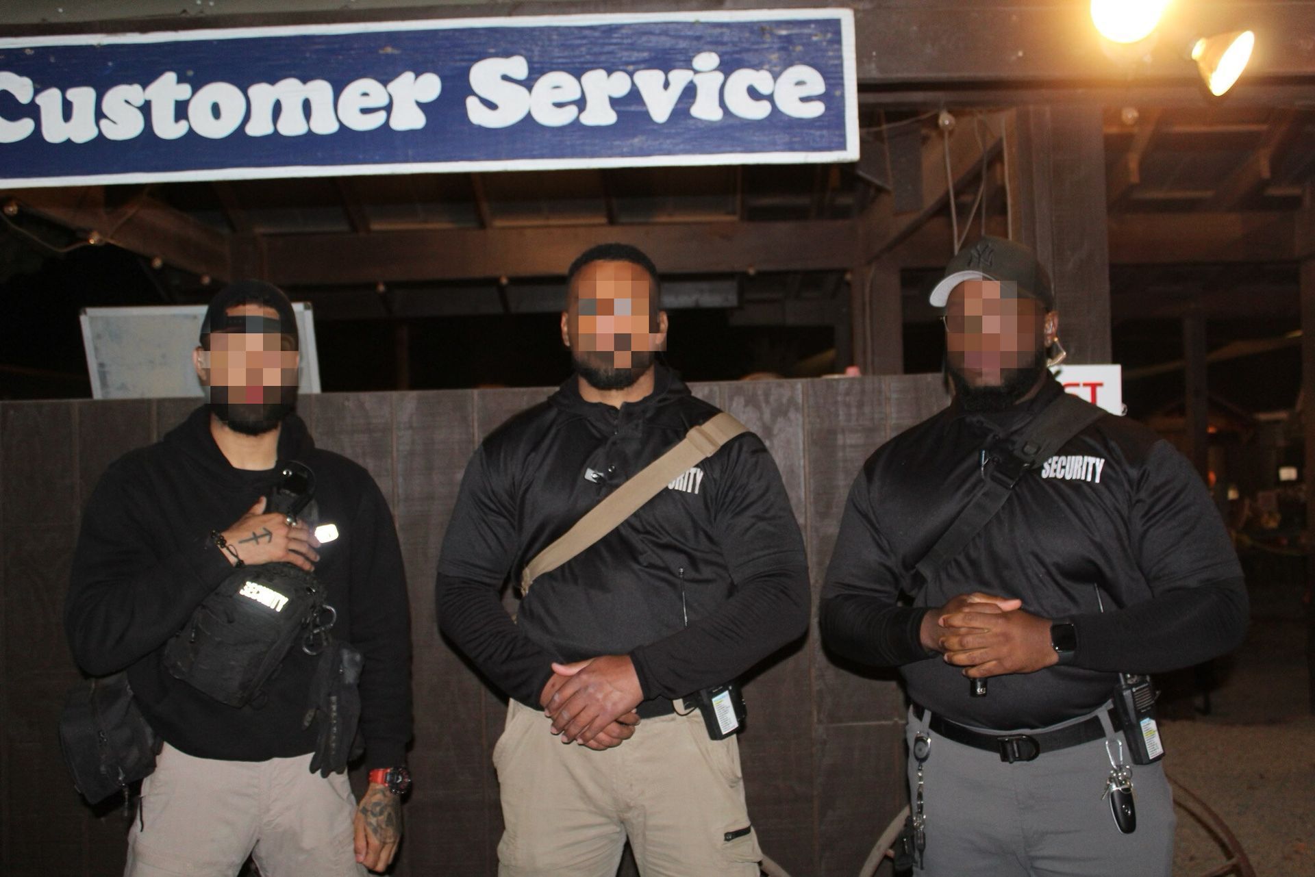 Three security personnel stand beneath a 