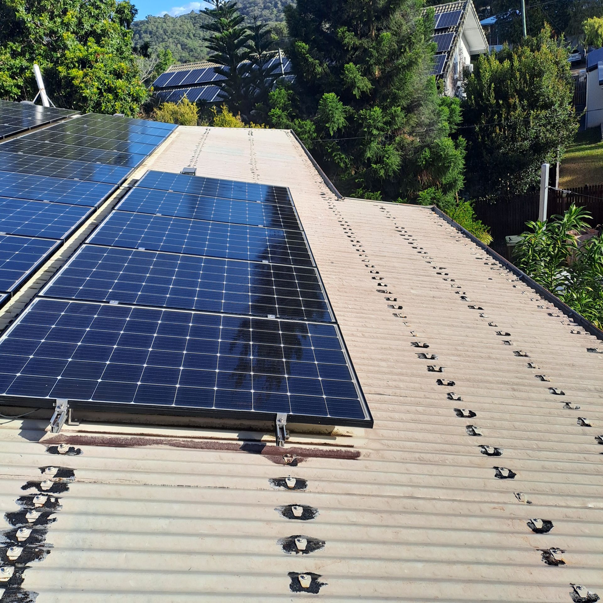 Solar panels installed on a corrugated metal roof of a house — Busy Bees Blasting in Trinity Beach, QLD