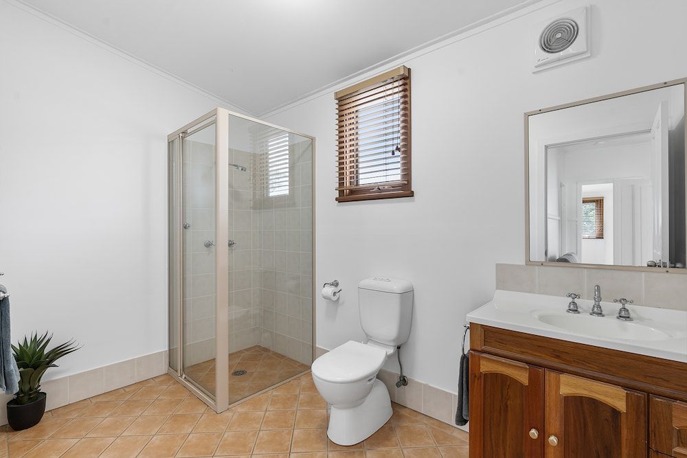 A Bright Bathroom Featuring a Walk-in Glass Shower, Toilet, and Vanity — SeaChange Parks Milton in Lake Conjola, NSW
