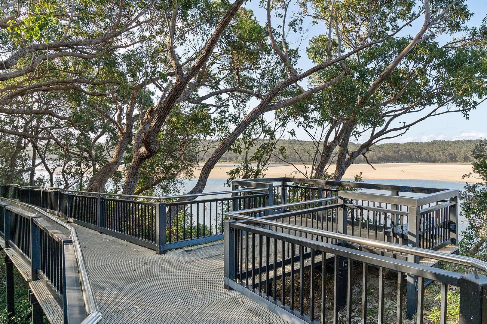 Wooden Boardwalk With Railings Winds Through Trees Overlooking Water — SeaChange Parks Milton in Milton, NSW