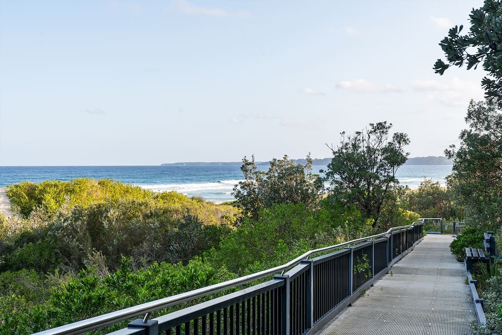 Wooden Boardwalk with Railings Overlooking Beach and Ocean — SeaChange Parks Milton in Lake Conjola, NSW