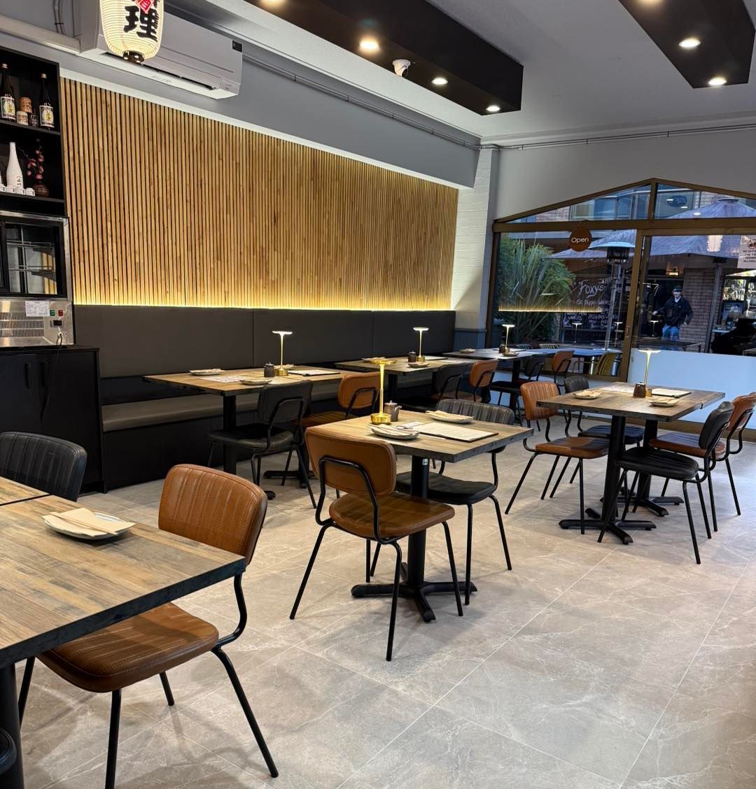 Modern restaurant interior with wood-paneled walls, dining tables, and leather chairs — SeaChange Parks Milton in Milton, NSW