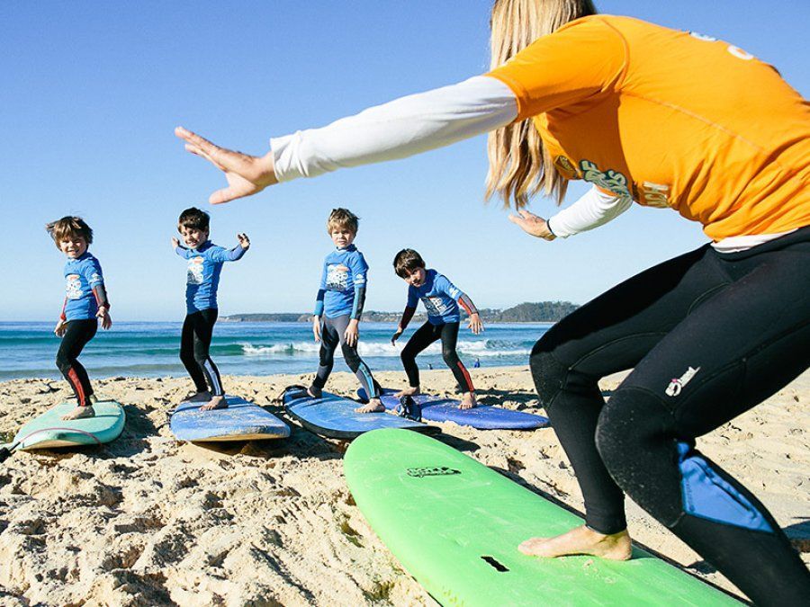 Surfing Instructor Teaching Children on Surfboards at the Beach — SeaChange Parks Milton in Milton, NSW